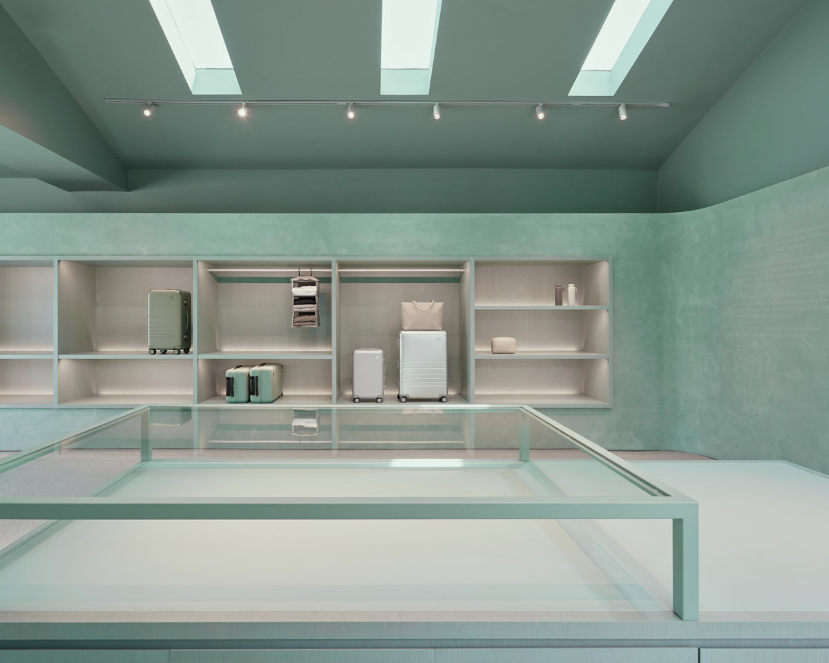 Modern interior with glass display case and shelves against a light green wall.