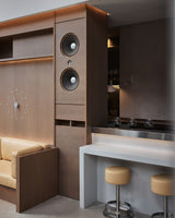 Modern kitchen with wooden cabinets, a bar area, and a beige sofa.