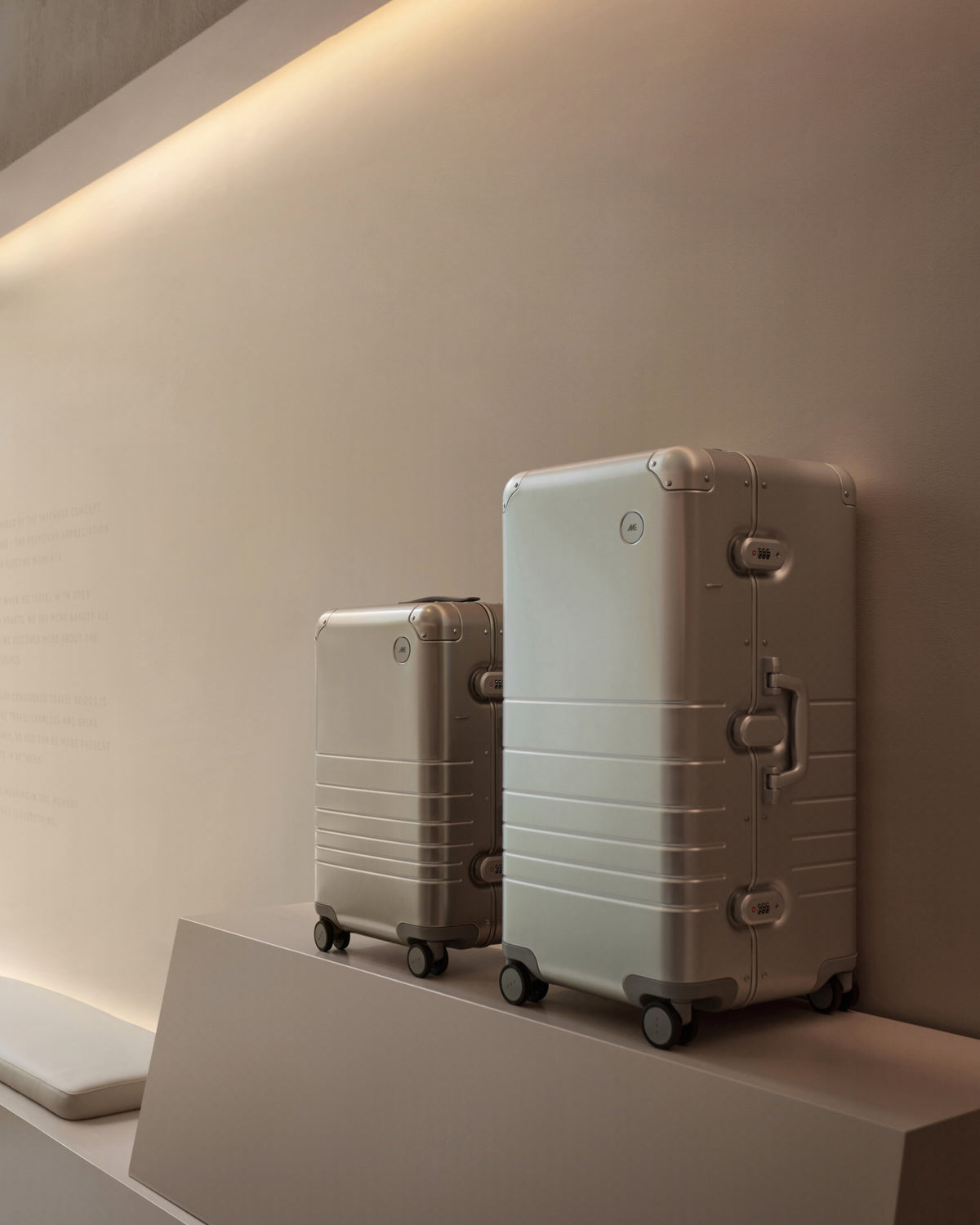 Monos Hybrid Collection luggage displayed on a pedestal inside the Boston store’s minimalist interior.
